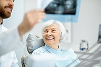 patient looking at dentist with X-ray 