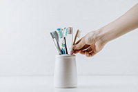 Hand reaches for toothbrush