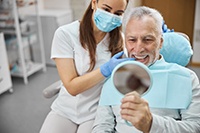 patient smiling in dental mirror 