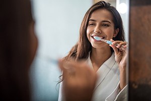 Woman brushing teeth in Collierville