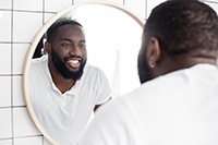 Man smiling at reflection in bathroom mirror