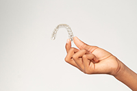Teen holding clear aligner