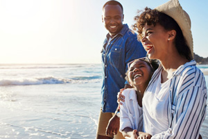 Invisalign patient in Collierville smiling with family on the beach