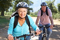 Senior couple smiling while riding bikes outside