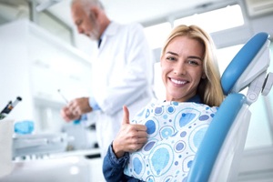woman giving thumbs up in dental chair 