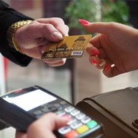 Man handing woman credit card for payment