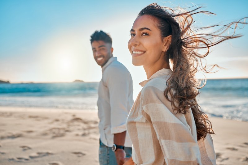 A smiling couple traveling on a beach